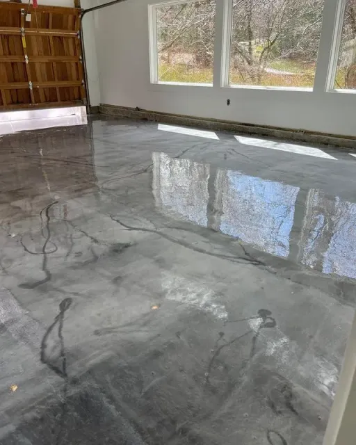 Polished gray concrete floor reflects light in a bright room with windows. Garage door visible.