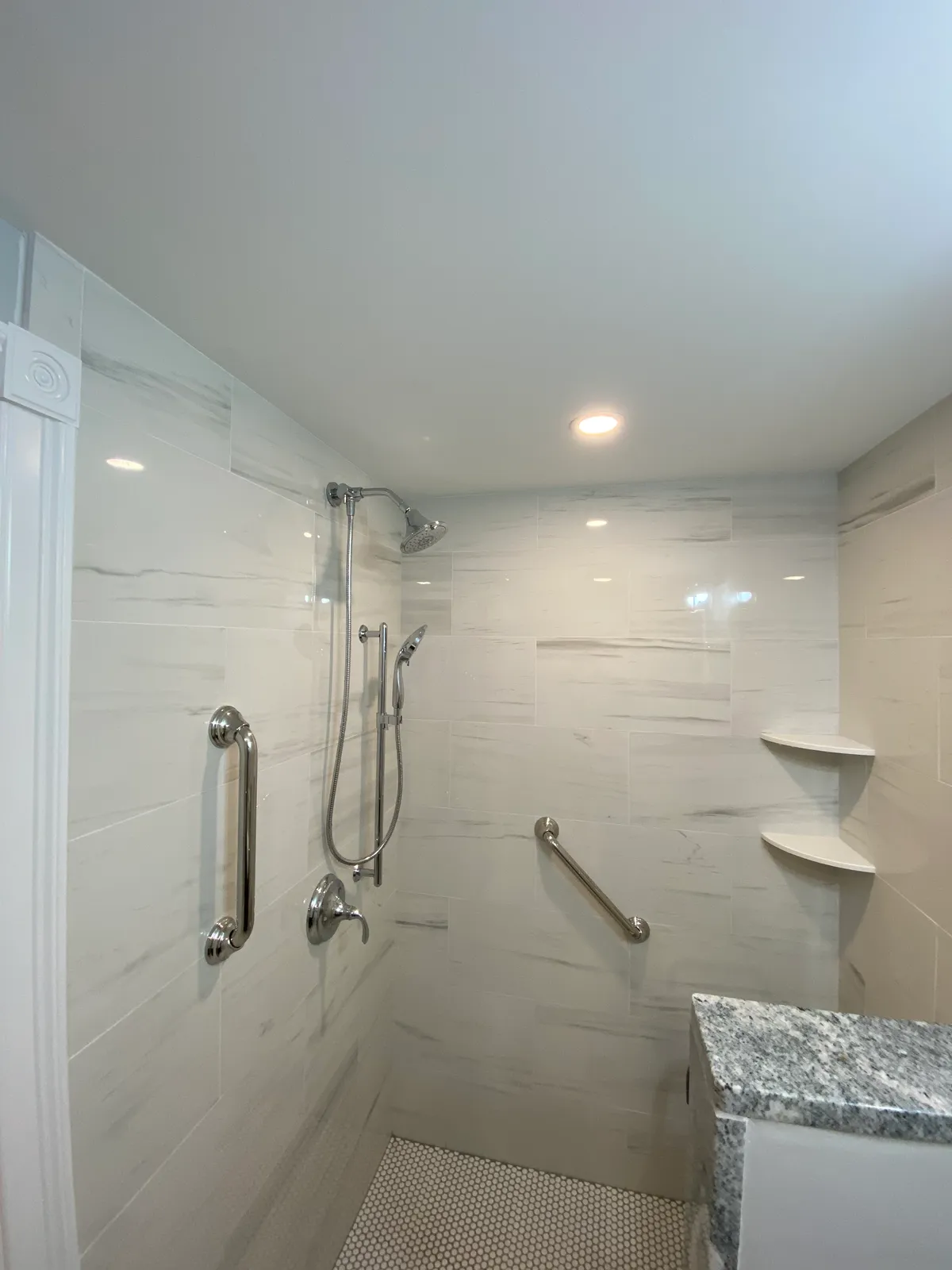 Bathroom shower with marble tile and chrome fixtures