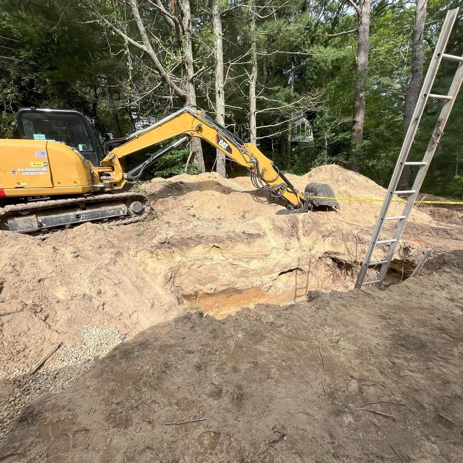 Excavator digging foundation trench for residential construction