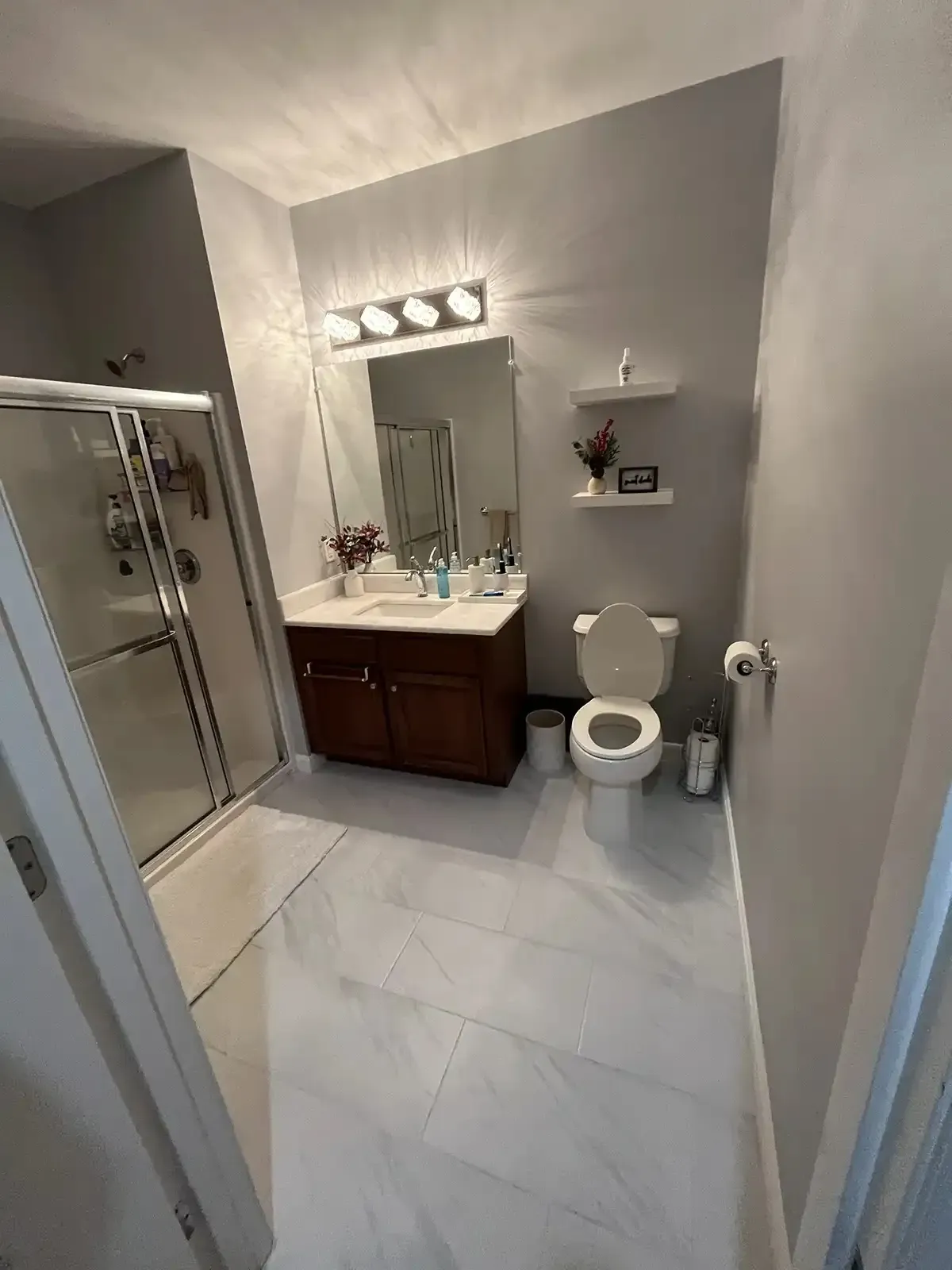Remodeled full bathroom with large-format tile floor