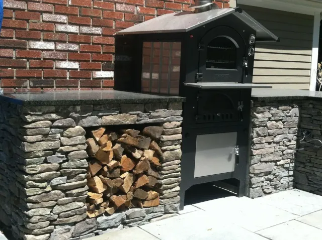 A brick wall with a stack of logs behind it