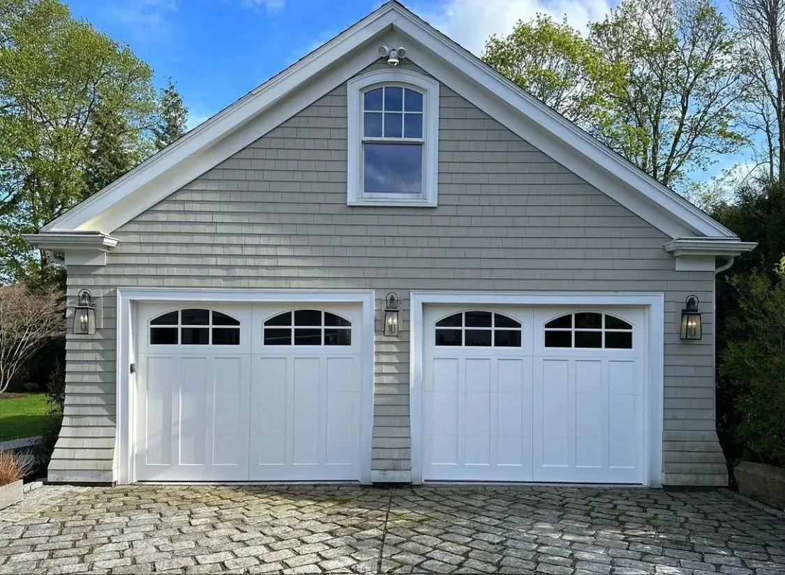 A garage with two white doors and a window