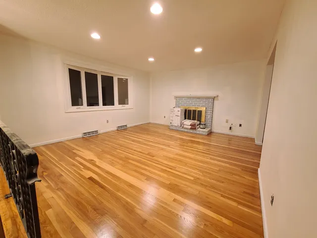 Refinished hardwood floor beside a fireplace