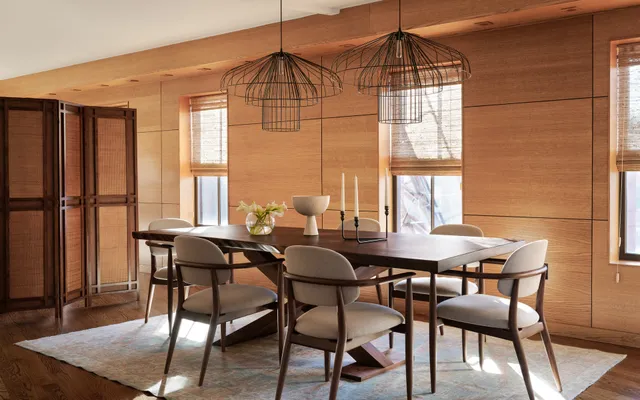 A dining room table with chairs and a chandelier