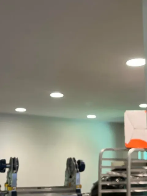 A ladder is sitting under a ceiling in a room.