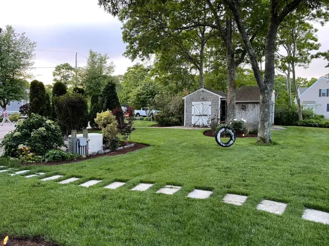 Green lawn with stepping stones leading to a main entrance.