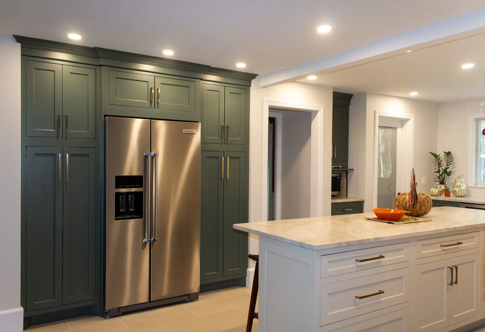 Green cabinetry kitchen with quartz island
