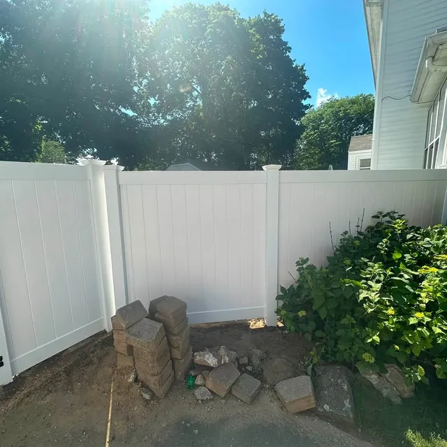 White vinyl privacy fence beside a house