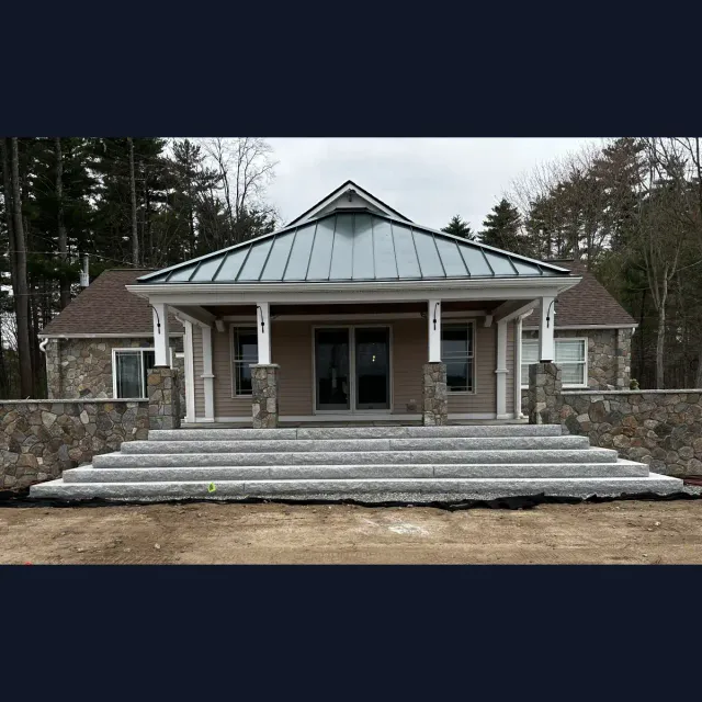 Granite staircase connecting the back yard to the house through a raised patio