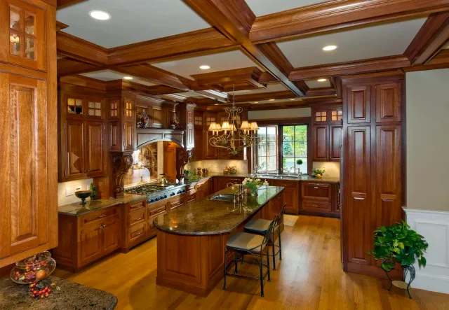 Traditional kitchen with dark wood cabinets, granite countertops, chandelier, and large window overlooking garden.