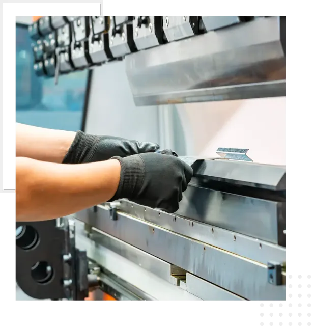 Gloved hands adjusting metal sheet on press