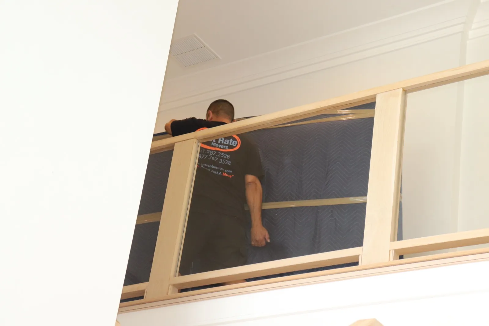 Boston Best Rate Movers crew member moving a mattress on the upper level