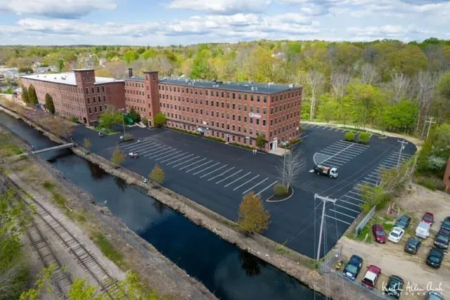 Red brick factory overlooking a canal and parking lot