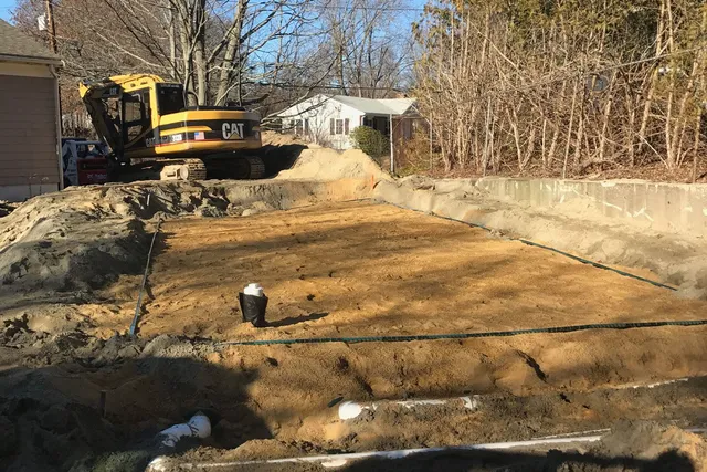 A construction site with a yellow tractor and dirt.