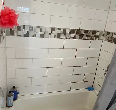 Clean bathtub and tiled bathroom wall