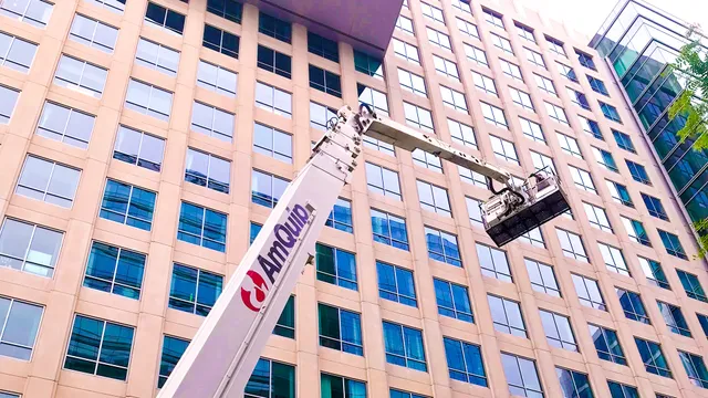 Workers on a lift next to a building