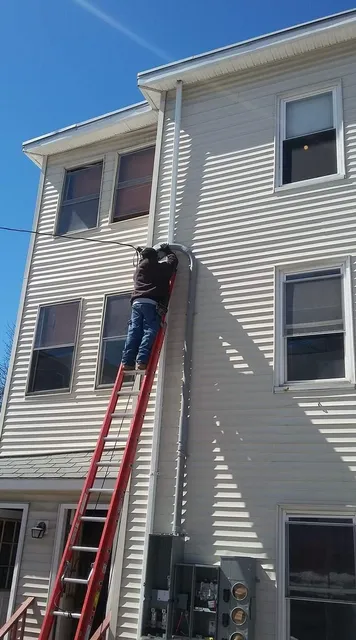 Overhead service drop and mast work on a three-decker
