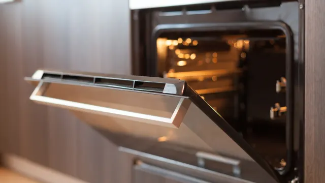 A close up of an oven with the door open in a kitchen.