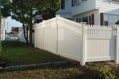 White vinyl privacy fence and gate beside a house
