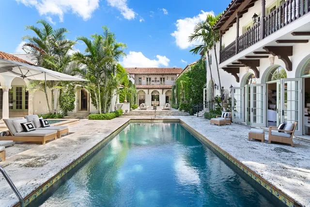 Mediterranean courtyard pool with palms and travertine paving