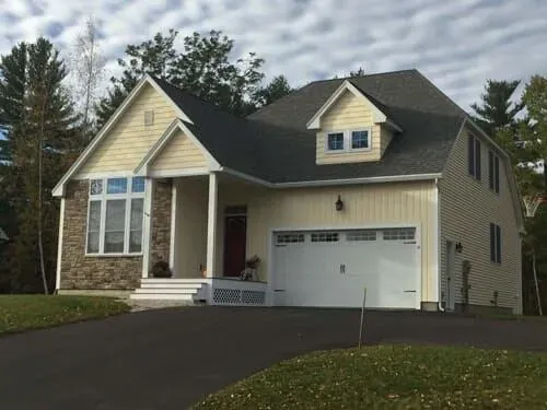 A yellow house with a white garage door