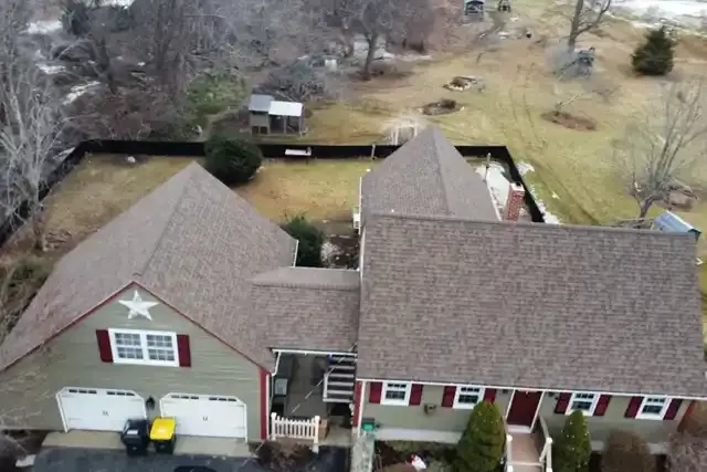 Aerial view of a residential property in New Bedford, showcasing a well-maintained roof, landscaped yard, and surrounding outdoor space, emphasizing N.E. Building & Restoration's expertise in roofing and home restoration services.