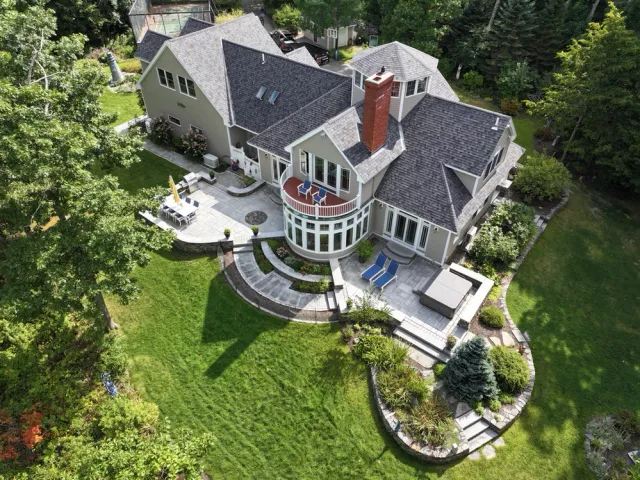 Aerial view of a house with patios and lush landscaping