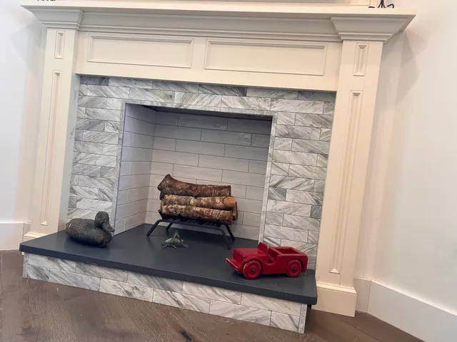 White mantle and marble tile fireplace closeup