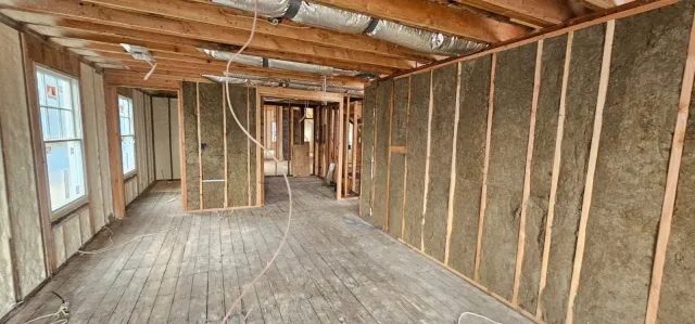 A room with wooden walls and a wooden floor in a house under construction.