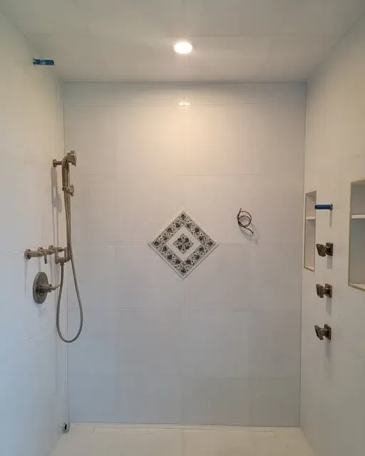 a bathroom with a walk-in shower and a diamond design on the wall