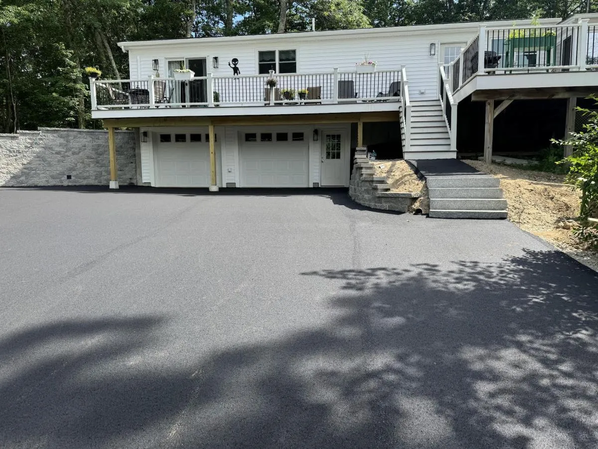 Paved asphalt driveway finished beside granite front steps