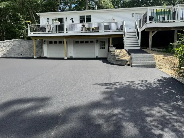 Paved asphalt driveway finished beside granite front steps