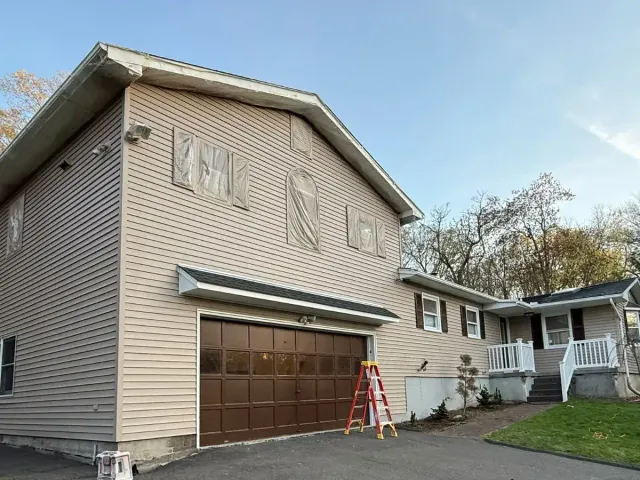 House exterior after full paint job tan siding and brown garage