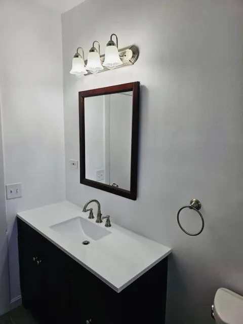 a bathroom with a sink , mirror and toilet .