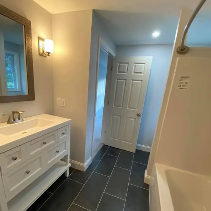 Finished full bath with double vanity and slate-look tile floor