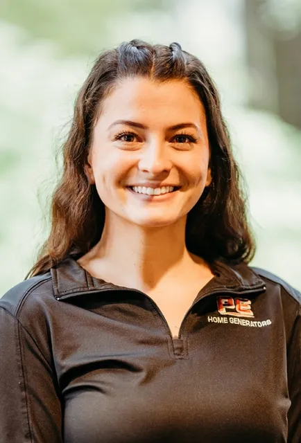 Woman in a black PE Home Generators shirt smiling.