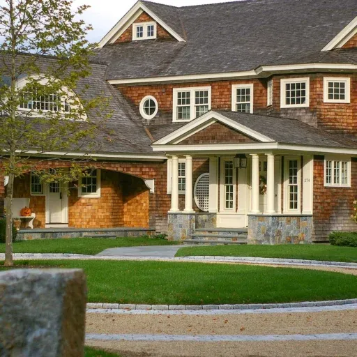 A Duxbury circular driveway pairs elegant masonry, structured planting, and a graceful arrival sequence that enhances curb appeal and daily function.