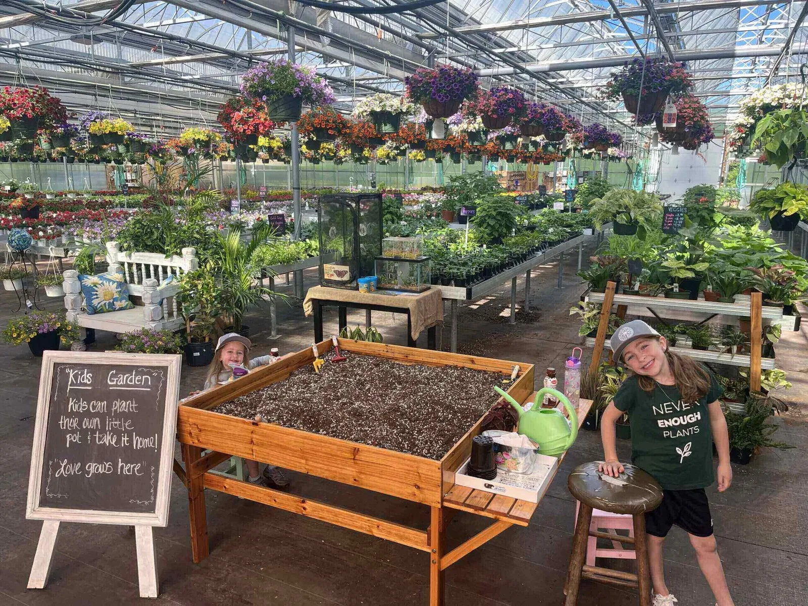 Smiling girl beside planting table in greenhouse