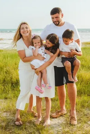 the owner of Richie's Roofing and his family on the beach