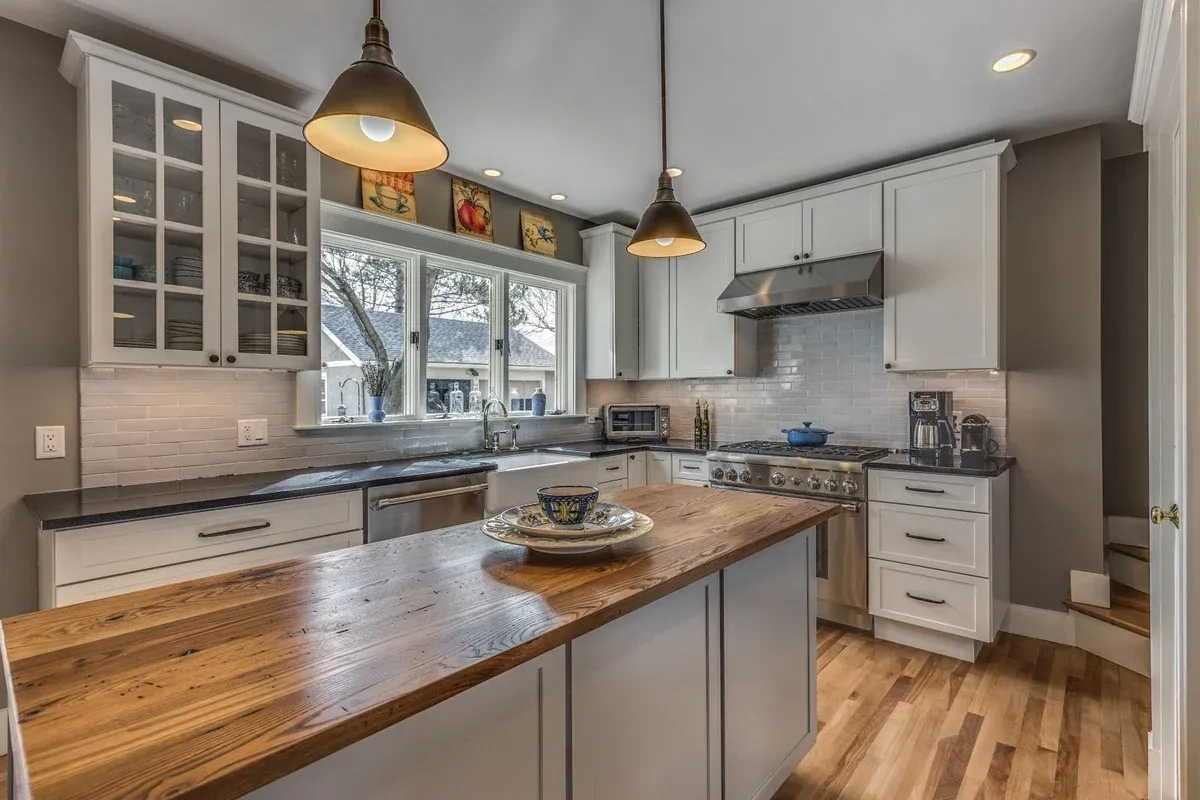 Wide view of kitchen remodel in Melrose MA by PEGASUS Design-to-Build with wood island and white cabinetry-optimized