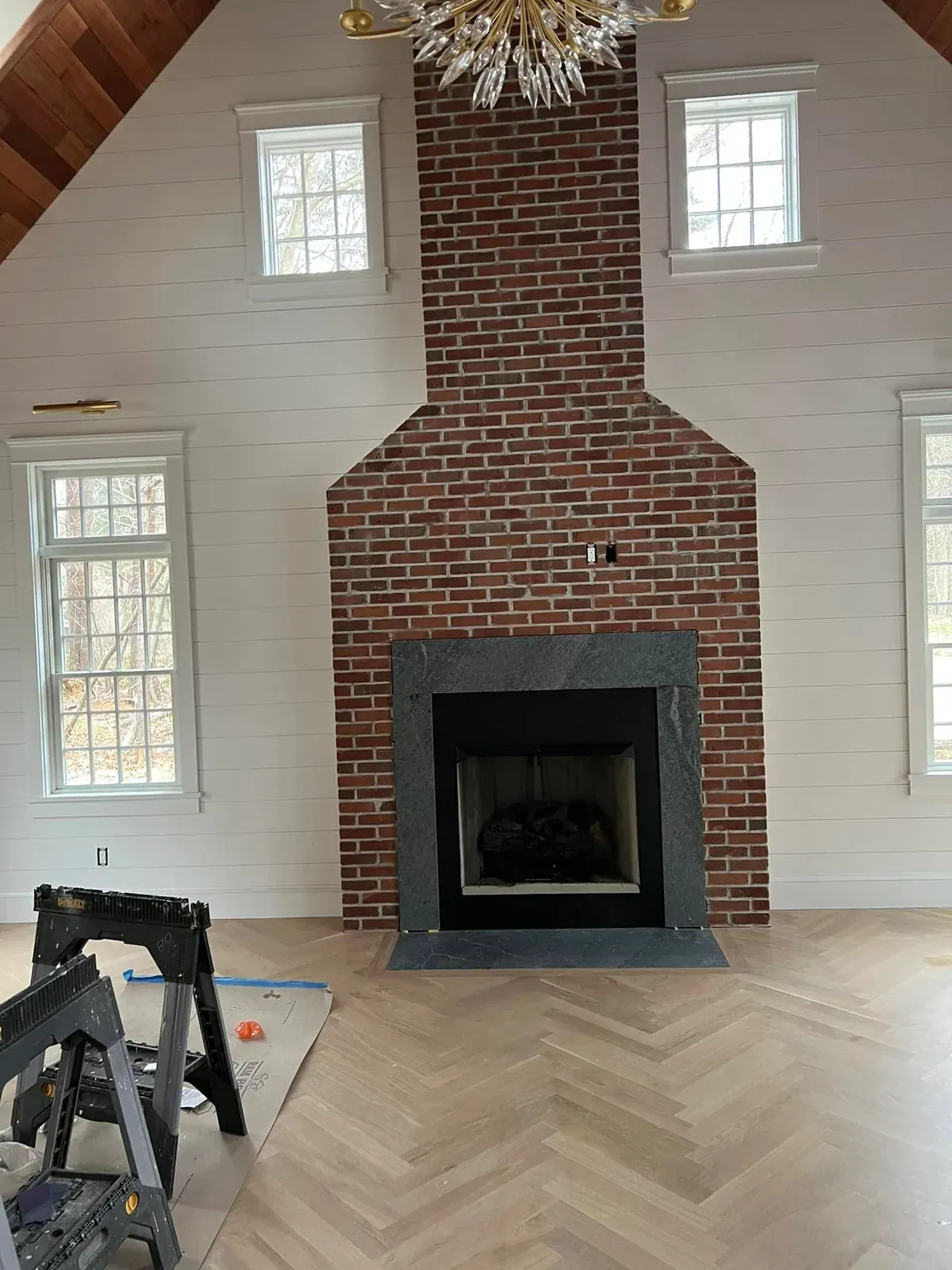 Tall brick fireplace centered in a vaulted interior