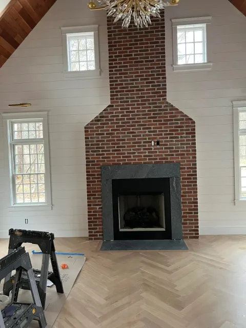 Tall brick fireplace centered in a vaulted interior