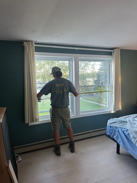 Bowe Contracting worker measuring window frame during a residential renovation in New Hampshire