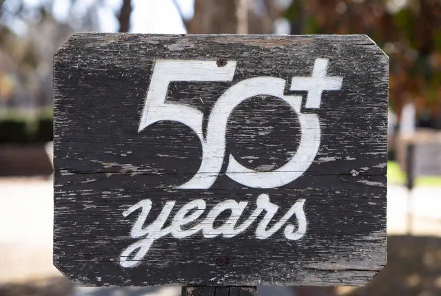 Weathered wood sign reading “50+ years”