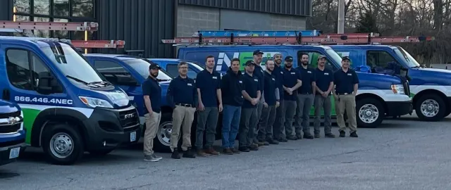 The NEC service crew in front of the van fleet