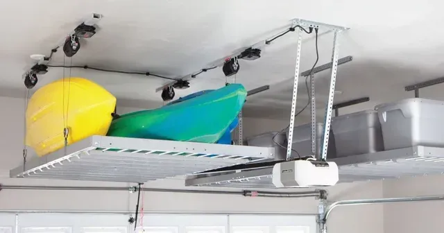 a kayak is sitting on top of a ceiling rack in a garage .