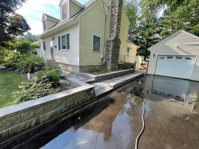 Stone-faced retaining wall and steps along a driveway