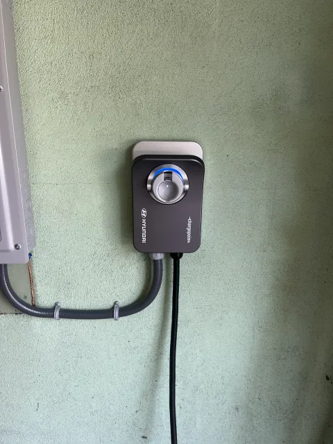 A black timer is attached to a green wall.