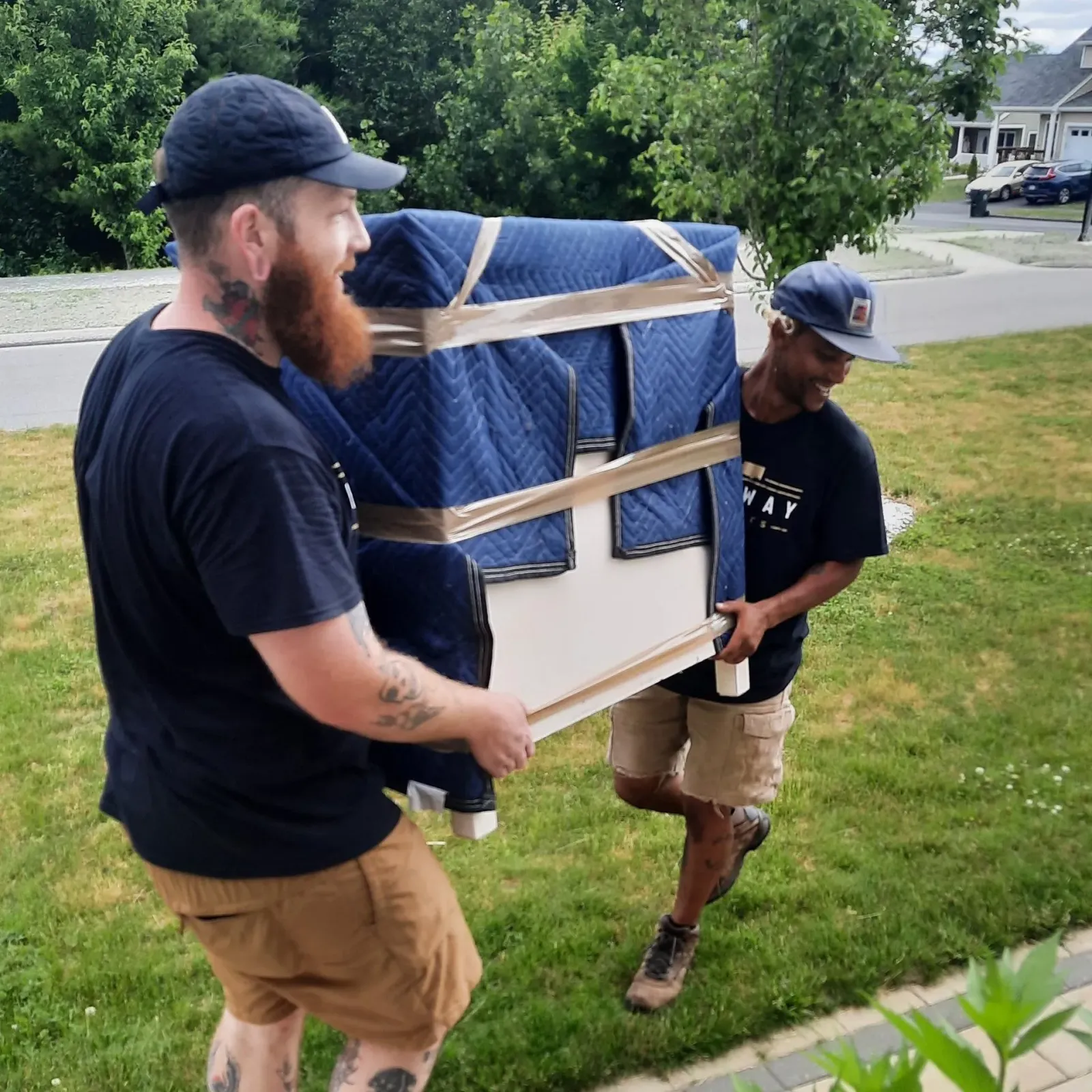 Two men are carrying a large piece of furniture