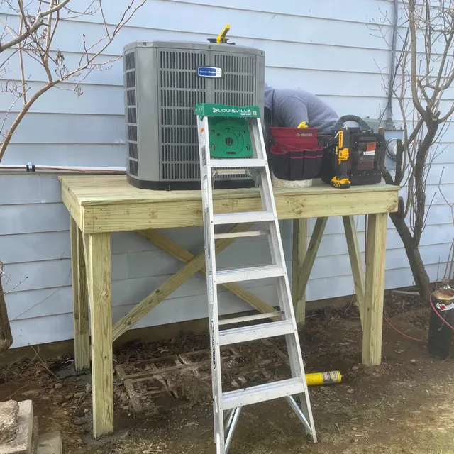 The Heating and Cooling Company Working fixing AC Unit